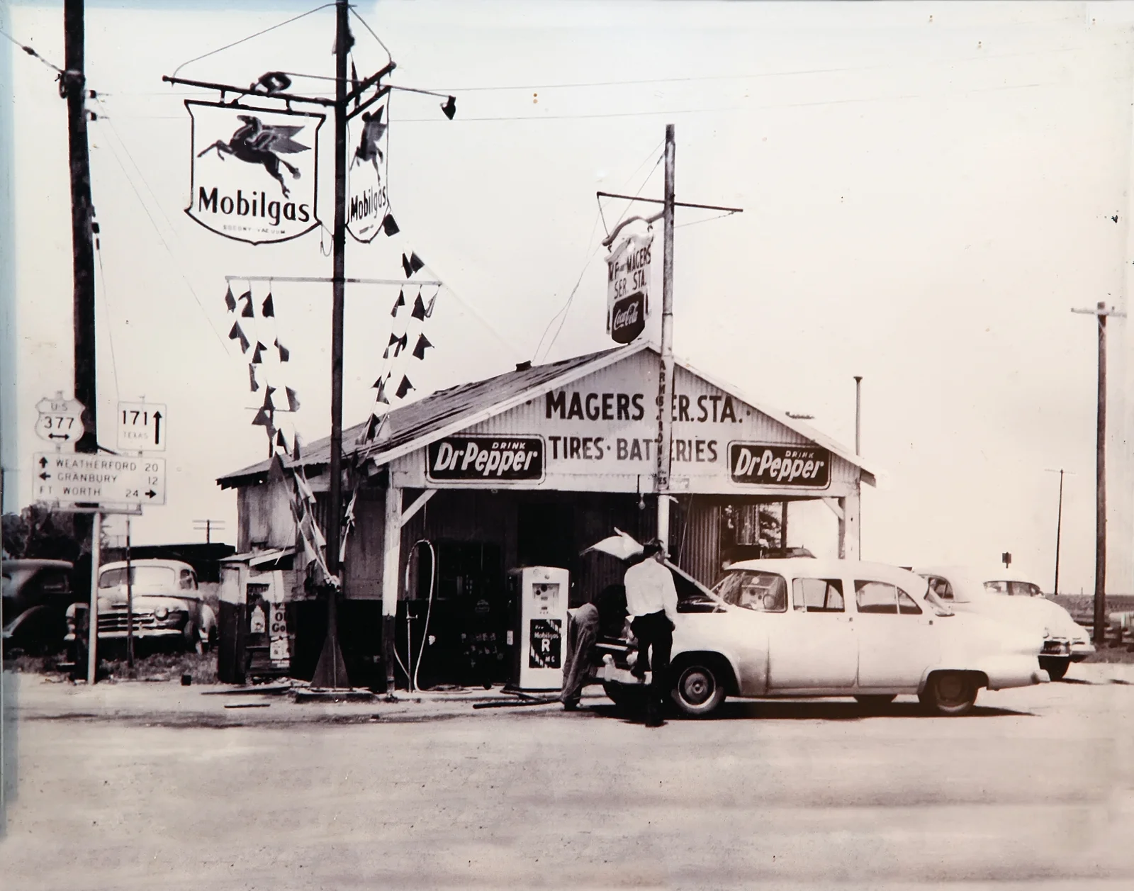 Historic Magers Mobilgas station in Cresson with vintage cars and US 377 and Texas 171 signs